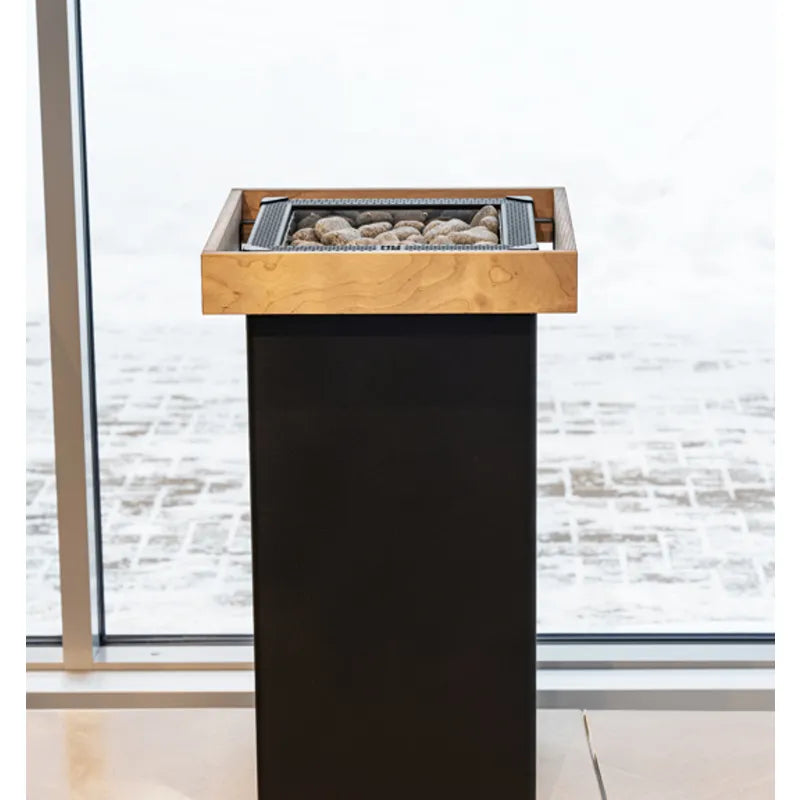 Huum Core Black elektrischer Saunaofen Standofen mit Holzrahmen und Saunasteinen in modernem Innenraum