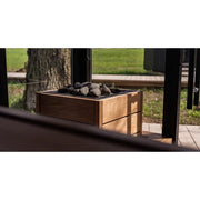 Huum Core Black elektrischer Saunaofen mit Steinen in moderner Holzummantelung auf Gartenterrasse