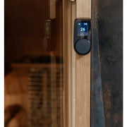Huum Core Black Saunaofen mit digitaler Steuerung an Saunatür, Display zeigt 94°C und 26% Luftfeuchte