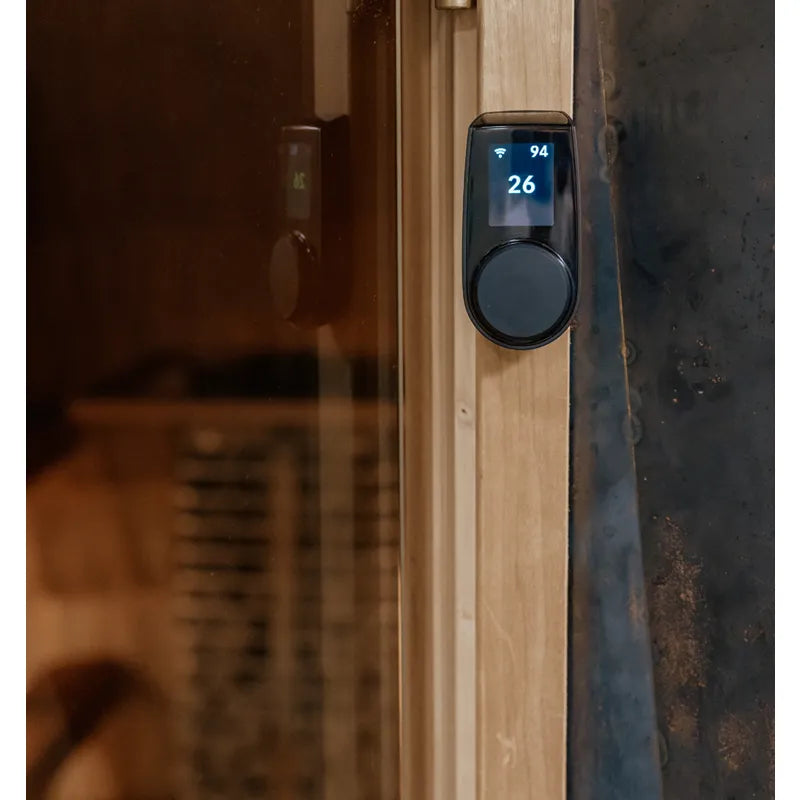 Huum Core Black Saunaofen mit digitaler Steuerung an Saunatür, Display zeigt 94°C und 26% Luftfeuchte