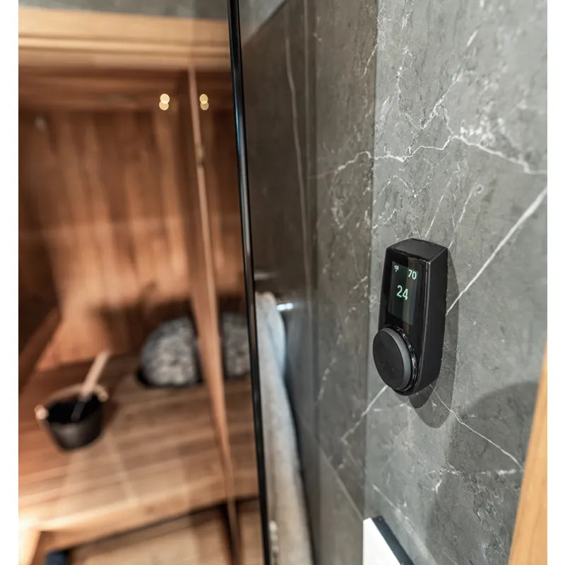 Huum Core Black elektrischer Saunaofen mit digitaler Steuerung an Wand montiert, modernes Design in Saunaraum