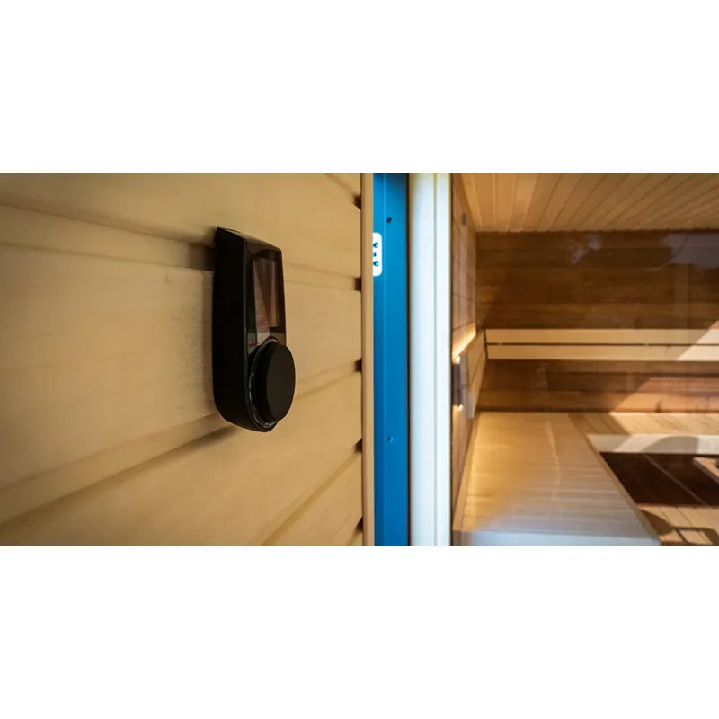 Huum Core Black elektrischer Saunaofen montiert in moderner Innensauna mit Holzverkleidung und blauem Rahmen