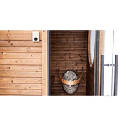 Huum Core Black elektrischer Saunaofen Standofen mit Steinen im Inneren einer modernen Saunakabine mit Holzverkleidung