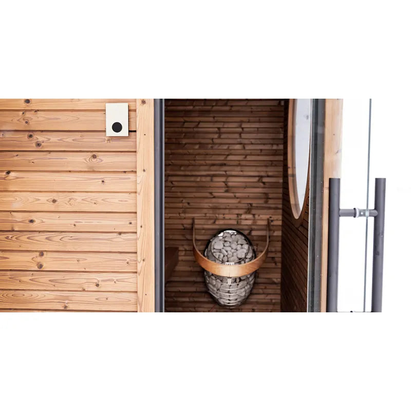 Huum Core Black elektrischer Saunaofen Standofen mit Steinen im Inneren einer modernen Saunakabine mit Holzverkleidung