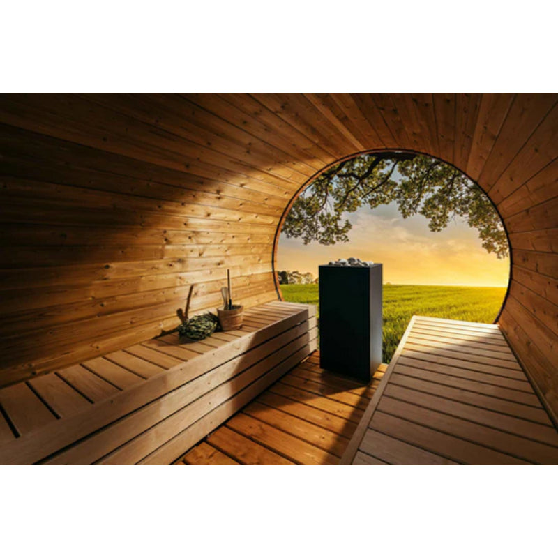 Moderne Fasssauna aus Holz mit Blick auf grüne Wiese, innen Holzbänke und schwarzer Huum Core Saunaöfen