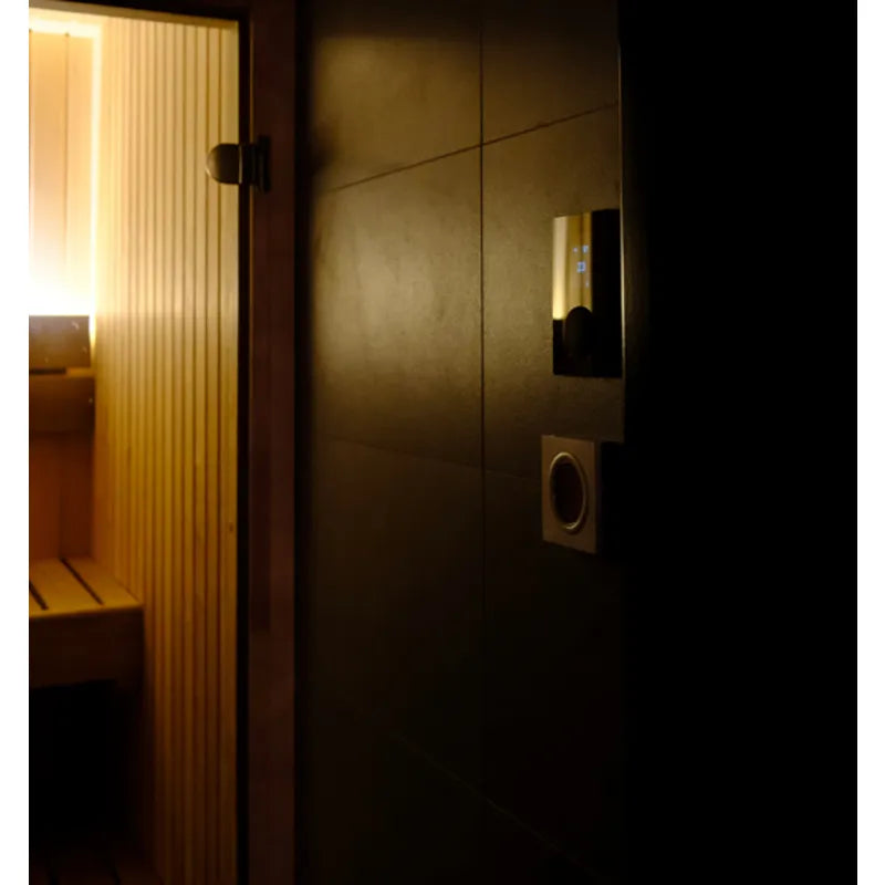 Huum Core Wall Mini Wandofen 3,6 kW Elektrosaunaofen an dunkler Wand in moderner Saunakabine montiert