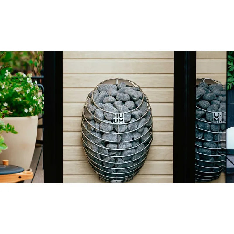 Huum Drop elektrischer Saunaofen mit Saunasteinen in modernem Garten-Setting, Wandofen für Sauna