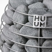 Huum Hive elektrischer Saunaofen Saunasteine mit Huum Branding auf Metallkorb