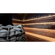 Huum Hive elektrischer Saunaofen mit Saunasteinen in moderner Wellness-Sauna mit Holzverkleidung