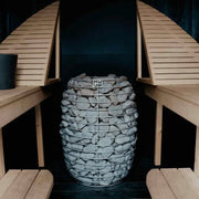 Huum Hive elektrischer Saunaofen 12/15/18 kW im Innenraum einer Sauna mit Holzbänken und Steinen