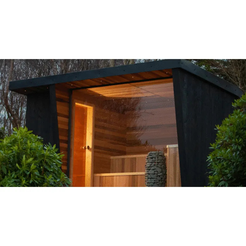 Huum Hive Mini elektrischer Saunaofen im modernen Gartenhäuschen mit schwarzem Rahmen und Holzverkleidung