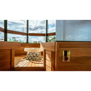 Huum Hive Mini elektrischer Saunaofen in moderner Sauna mit Holzbank und Panoramafenster