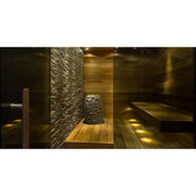 Huum Hive Mini elektrischer Saunaofen in moderner Sauna mit Holzbank und Steinwand
