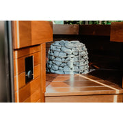 Huum Hive Mini elektrischer Saunaofen mit Saunasteinen in moderner Sauna mit Holzverkleidung