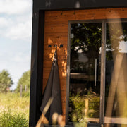 HUUM OVO Saunakimono – 100% OEKO-TEX Baumwolle hängend an Holzwand einer modernen Gartensauna