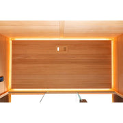 Innenansicht einer Infrarotkabine aus Hemlock-Holz mit warmweißer LED-Beleuchtung und Infrarot-Heizelementen an den Seitenwänden