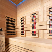 Innenansicht der EAGO AWT Infrarotkabine E1250A-IR mit Hemlock-Holzverkleidung, mehreren Infrarotheizpanelen und blauer LED-Deckenbeleuchtung für vier Personen.