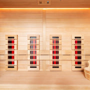 Innenansicht der EAGO AWT E1250A-IR Infrarotkabine mit Hemlock-Holz, vier Infrarot-Heizstrahler an der Wand, warm beleuchtete Decke und Holzbank rechts