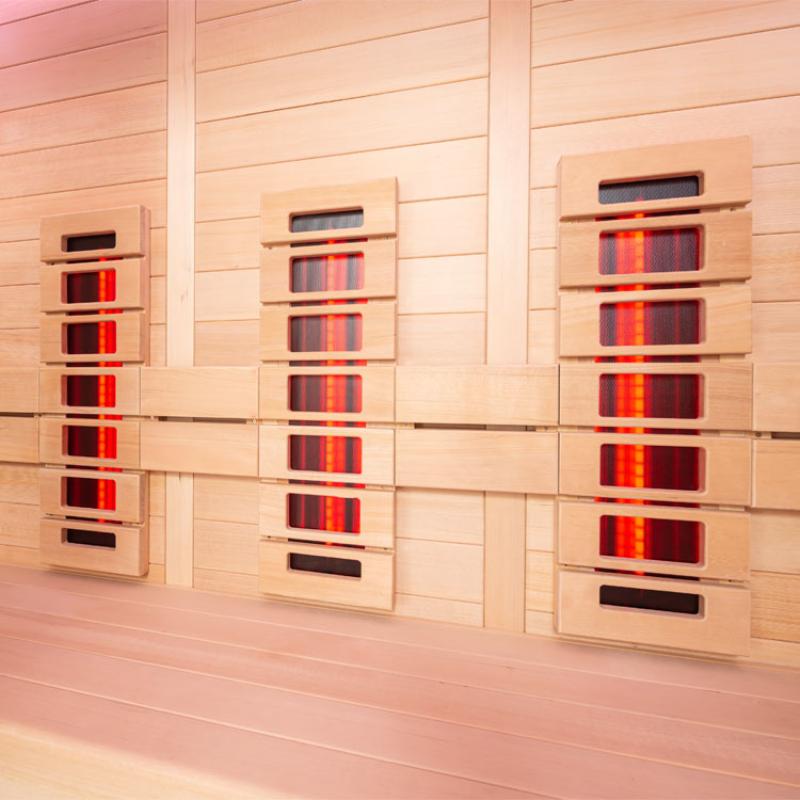 Drei nebeneinander angebrachte EAGO AWT Infrarotkabinen E1250B-IR aus Hemlock-Holz mit leuchtenden Infrarotstrahlern und Display, für Wellness im Innenbereich.