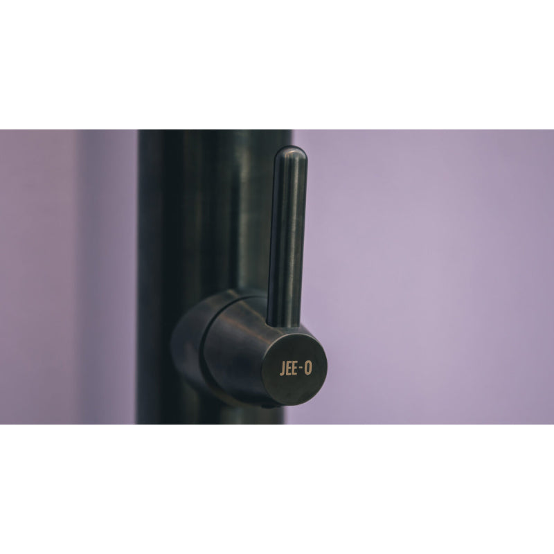 Detailaufnahme des Wasserhahn-Griffs der JEE-O Cone 01 Gartendusche in Schwarz mit charakteristischem rundem Design und Herstellerlogo