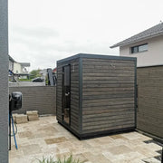 KOBA Block Gartensauna - Modernes Saunahaus mit schwarzem Holzdesign im Garten installiert