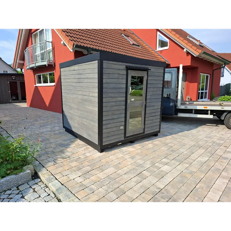 KOBA Block Gartensauna - Modernes Saunahaus mit grauer Holzverkleidung und schwarzem Rahmen im Garten