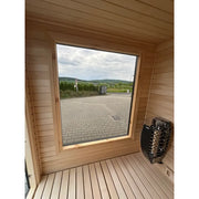 KOBA Cube Gartensauna Innenansicht mit Panoramafenster, Holzinterieur und Saunaofen