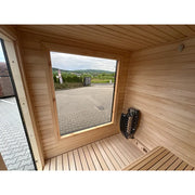KOBA Cube Gartensauna Innenraum mit Holzbank, Saunaofen und großem Fenster mit Gartenblick
