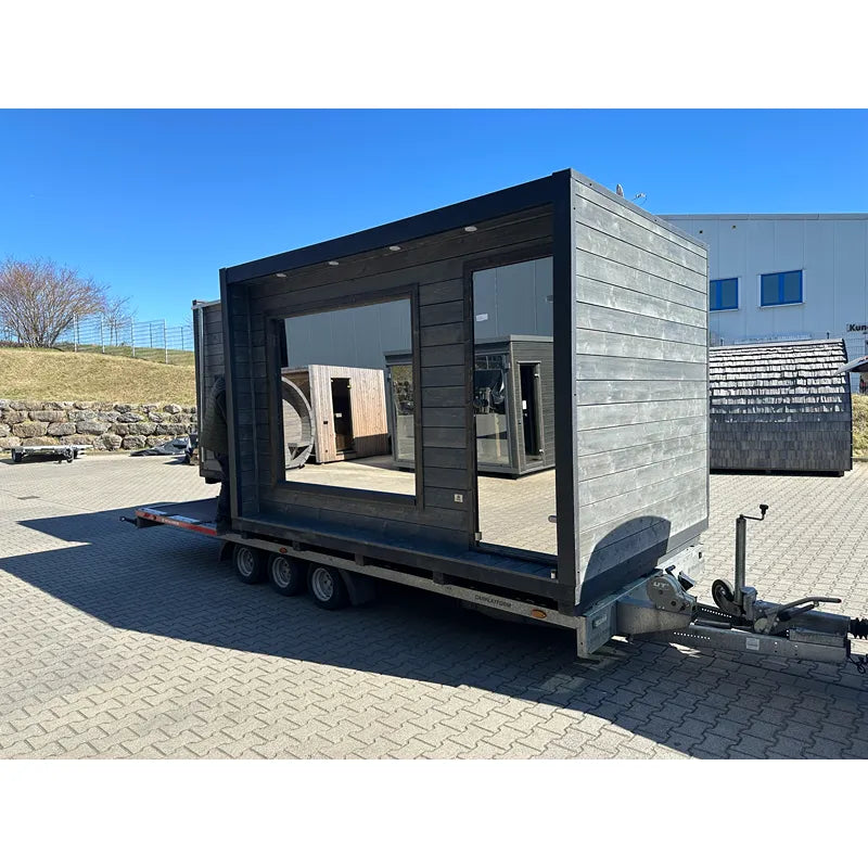 KOBA Cube Gartensauna - Moderne quadratische Form mit schwarzem Holzrahmen und großen Fenstern auf Ausstellungshof