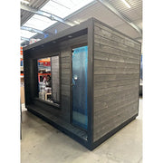 KOBA Cube Gartensauna mit moderner quadratischer Form, schwarze Holzverkleidung und großem Glasfenster