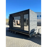 KOBA Cube Gartensauna - Moderne quadratische Form mit schwarzem Holzrahmen und großen Glasfenstern auf Anhänger