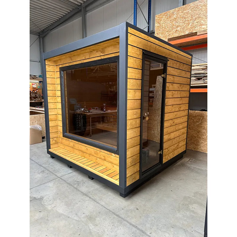 KOBA Cube Gartensauna - Moderne quadratische Form mit Holzverkleidung und großem Fenster in Lagerhalle