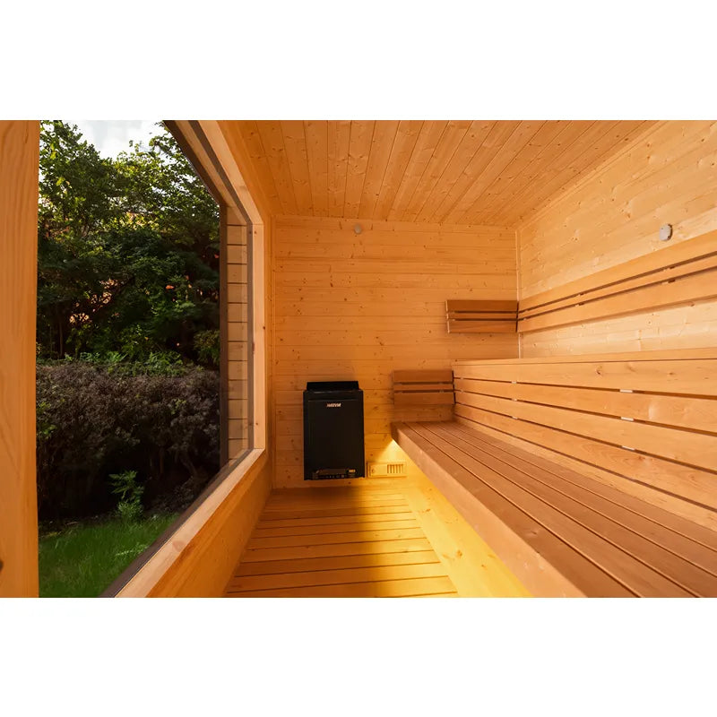KOBA Cube Gartensauna Innenraum mit Holzbänken, Saunaofen und Fenster zum Garten