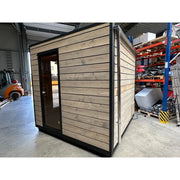 KOBA Cube Gartensauna - Moderne quadratische Form mit Holzverkleidung und schwarzem Rahmen in Lagerhalle