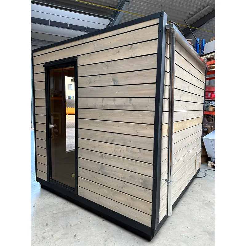 KOBA Cube Gartensauna - Moderne quadratische Form mit Holzverkleidung und schwarzem Rahmen in Werkstatt