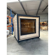 KOBA Cube Gartensauna moderne quadratische Form mit schwarzem Rahmen und Holzverkleidung in Werkstatt