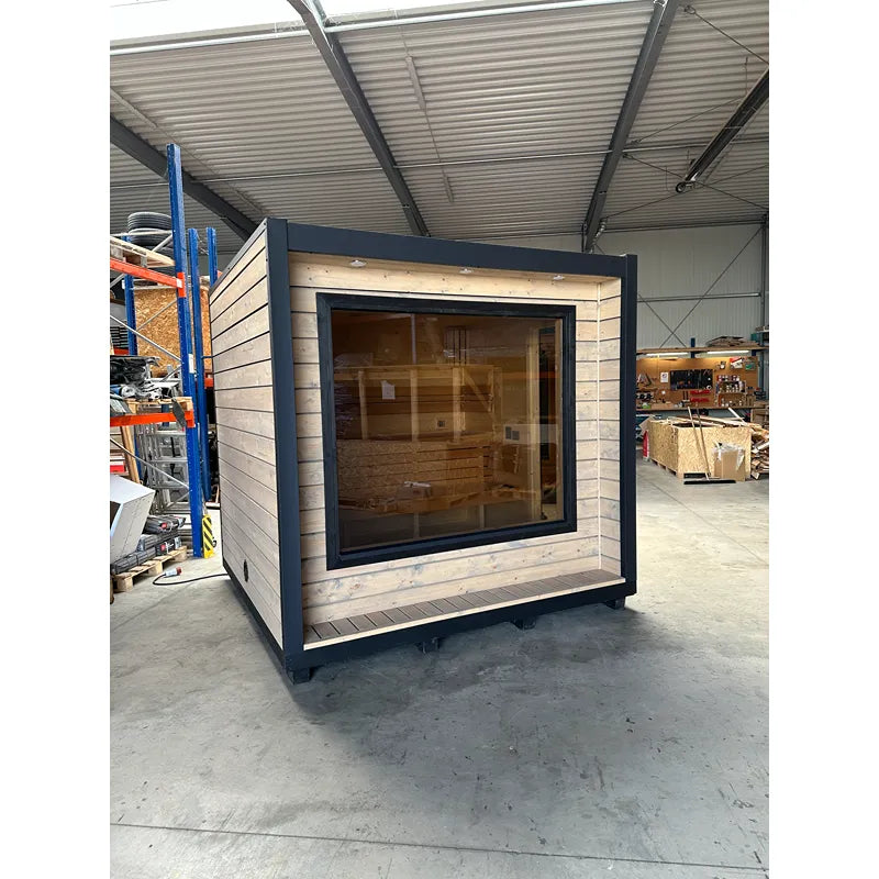 KOBA Cube Gartensauna moderne quadratische Form mit schwarzem Rahmen und Holzverkleidung in Werkstatt