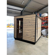 KOBA Cube Gartensauna - Moderne quadratische Form mit Holzverkleidung und schwarzem Rahmen in Lagerhalle