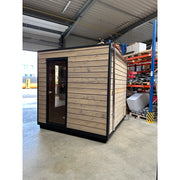 KOBA Cube Gartensauna - Moderne quadratische Form mit Holzverkleidung und schwarzem Rahmen in Lagerhalle