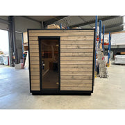 KOBA Cube Gartensauna - Moderne quadratische Form mit Holzverkleidung und schwarzem Rahmen in Fabrikhalle