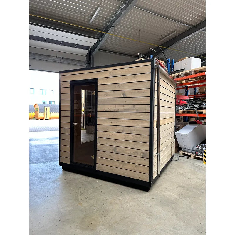 KOBA Cube Gartensauna - Moderne quadratische Form mit Holzverkleidung und schwarzer Tür in Lagerhalle