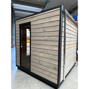 KOBA Cube Gartensauna moderne quadratische Form mit Holzverkleidung und schwarzem Rahmen in Werkstatt