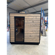 KOBA Cube Gartensauna - Moderne quadratische Form mit Holzverkleidung und schwarzem Rahmen in Lagerhalle