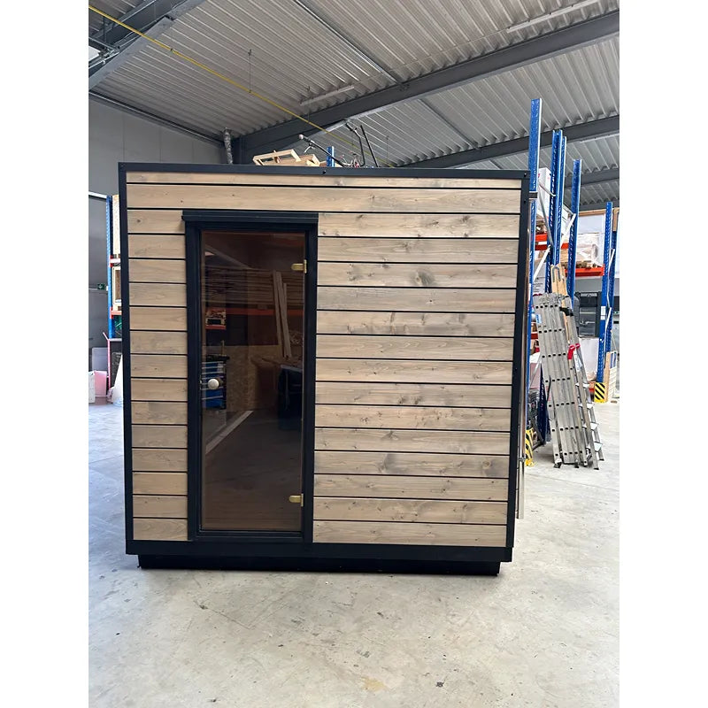KOBA Cube Gartensauna - Moderne quadratische Form mit Holzverkleidung und schwarzem Rahmen in Lagerhalle
