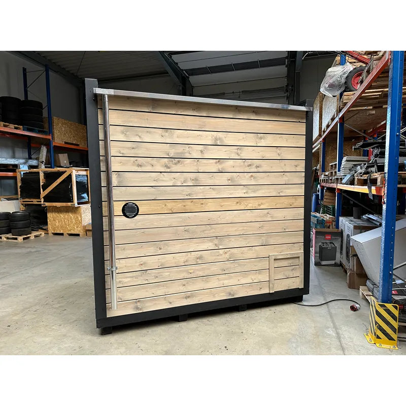 KOBA Cube Gartensauna - Moderne quadratische Form mit Holzverkleidung und schwarzem Metallrahmen in Lagerhalle