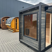 KOBA Cube Gartensauna - Moderne quadratische Form mit dunkelgrauem Rahmen und großem Panoramafenster in Gartenausstellung
