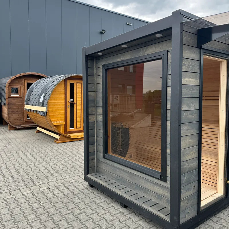KOBA Cube Gartensauna - Moderne quadratische Form mit dunkelgrauem Rahmen und großem Panoramafenster in Gartenausstellung