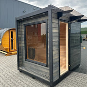 KOBA Cube Gartensauna - Moderne quadratische Form mit schwarzem Rahmen und großem Fenster im Garten