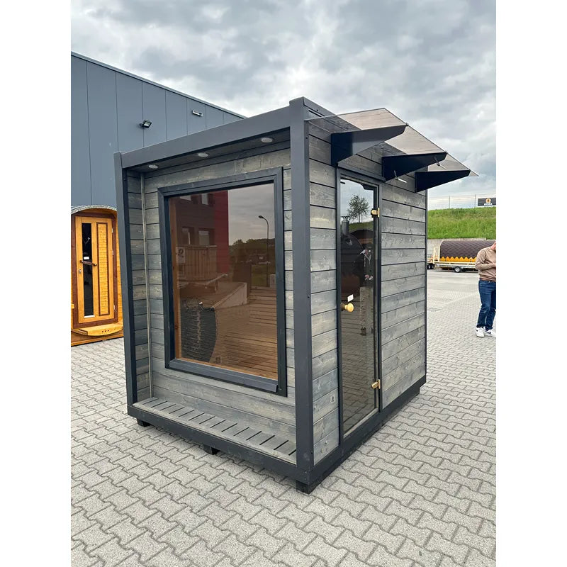 KOBA Cube Gartensauna - Moderne quadratische Form mit großem Fenster und Holzverkleidung im Gartenshowroom