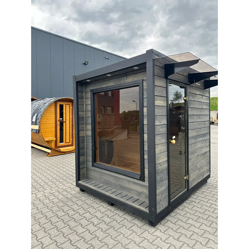 KOBA Cube Gartensauna - Moderne quadratische Form mit großem Fenster, dunkelgrauer Holzverkleidung und Terrasse